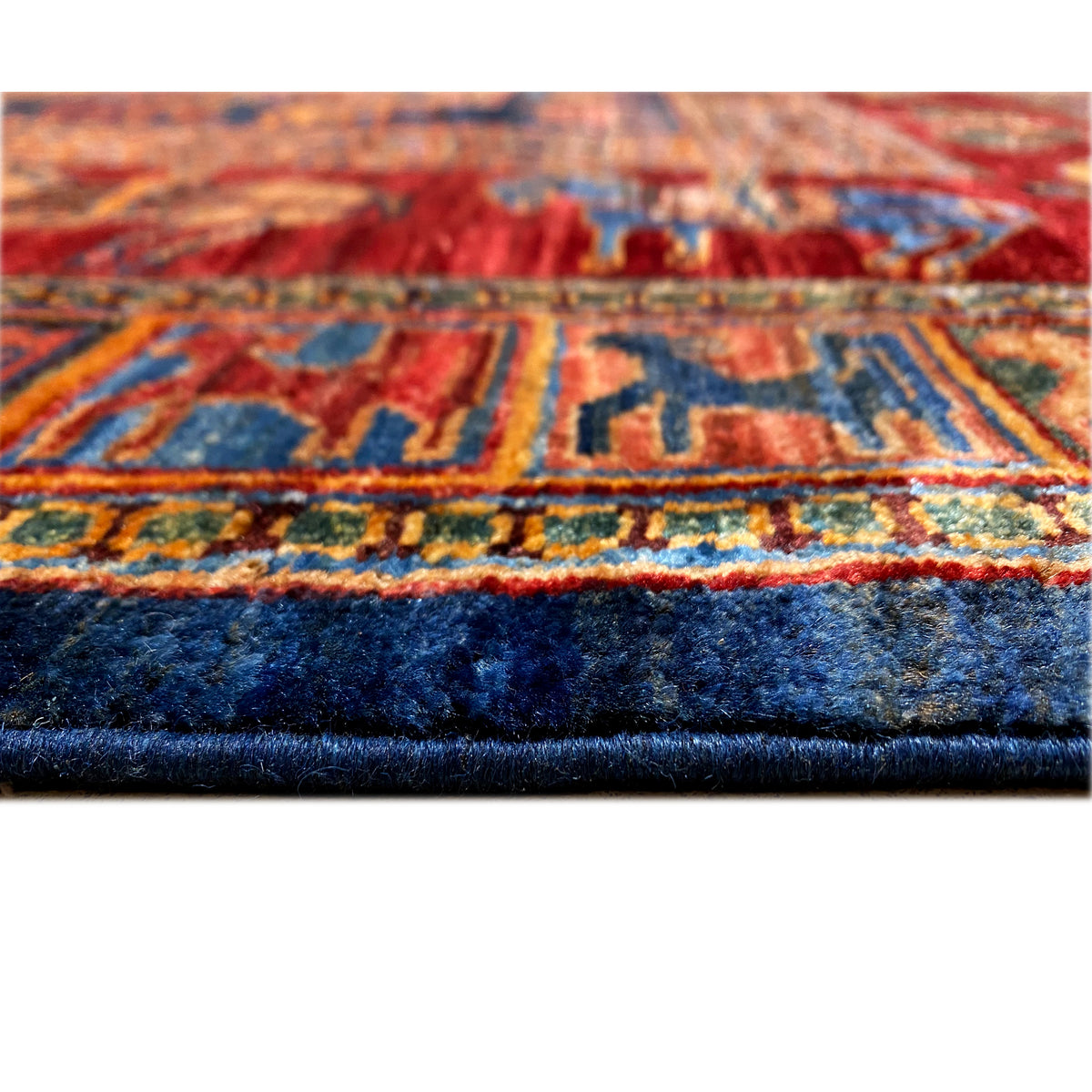 Close-up of the rug edge: multicolored borders with dense pile in the lower section