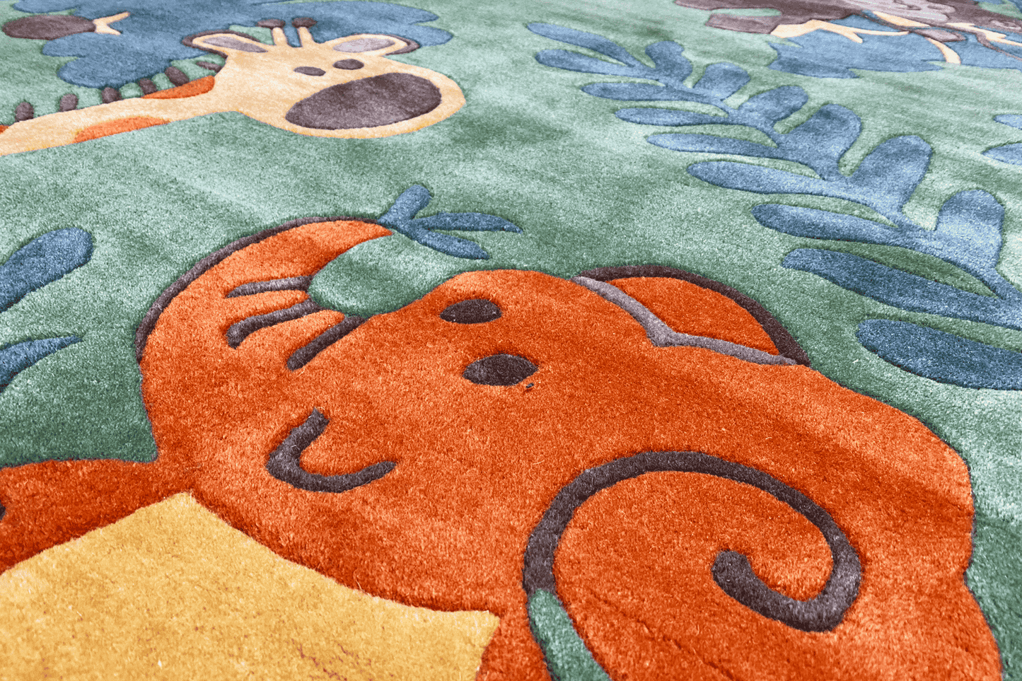 Carpet detail with an orange animal motif on a green background