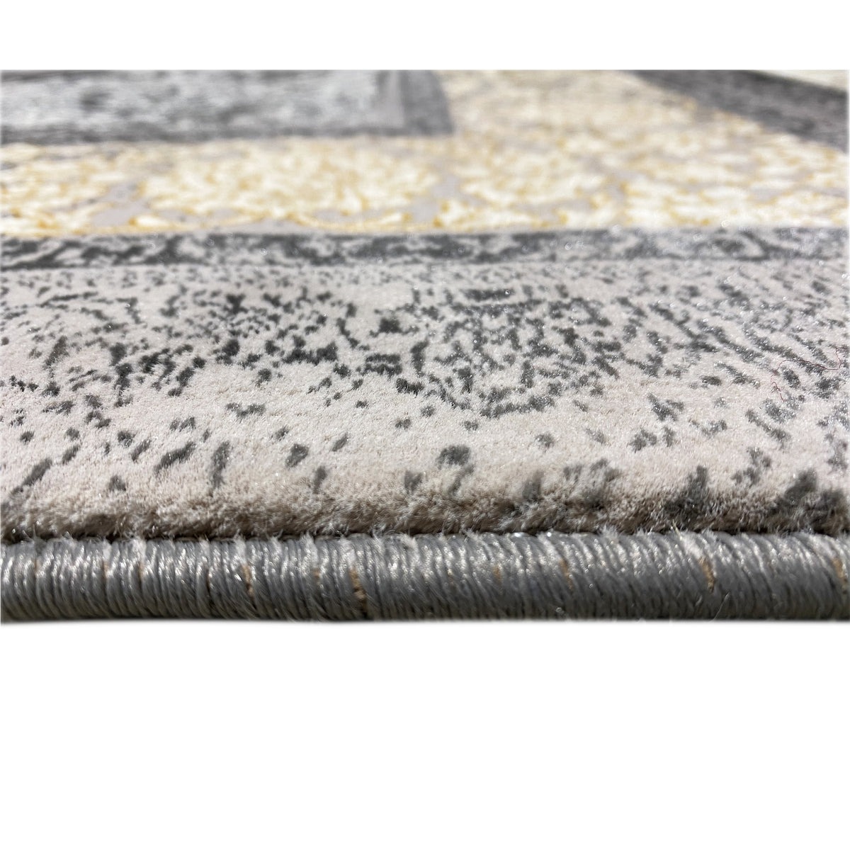 Rug detail: pile with dark patterns on a beige background, visible short fringes