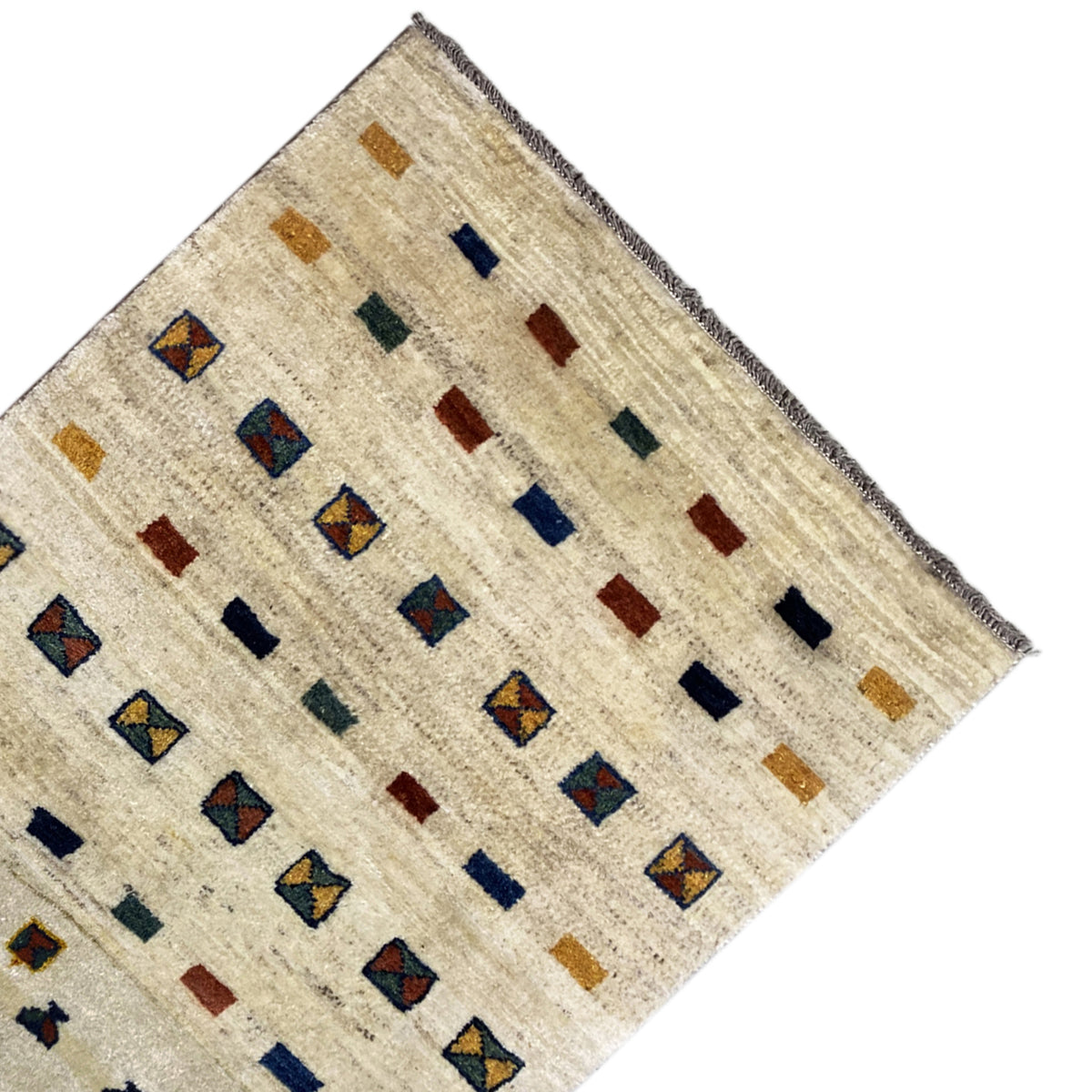 Corner of a Gabbeh rug: beige background with square patterns in blue and ochre