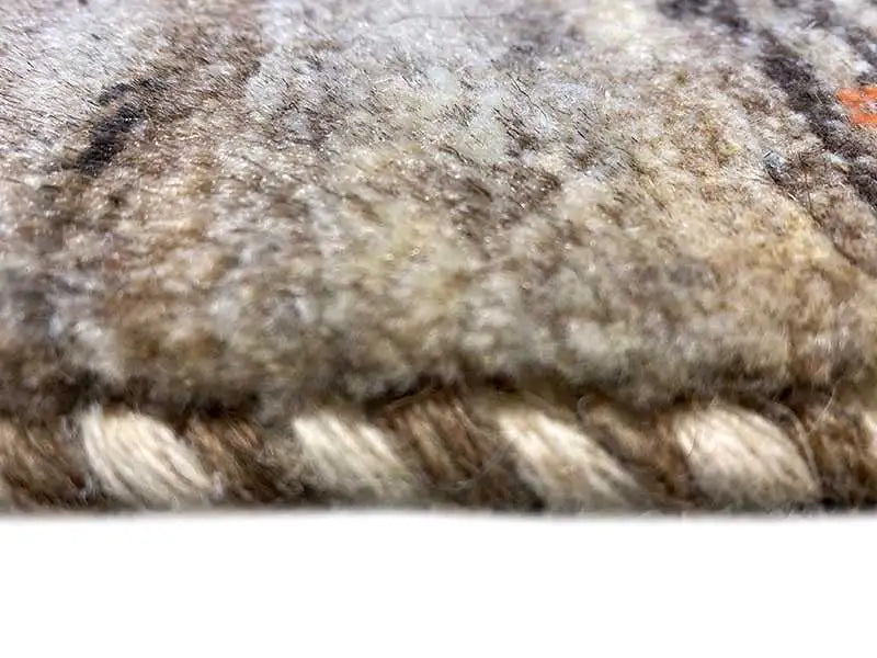 Gabbeh rug close-up of the pile: fluffy texture in beige, gray, and brown
