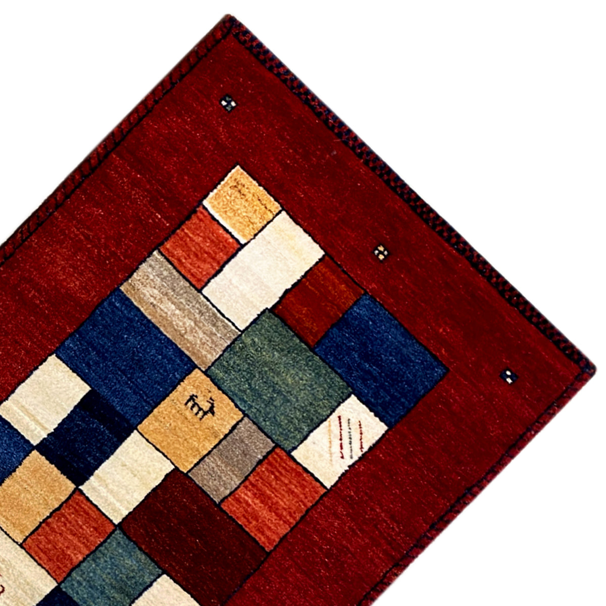 Corner view of the red Gabbeh runner rug with geometric sections in blue and beige