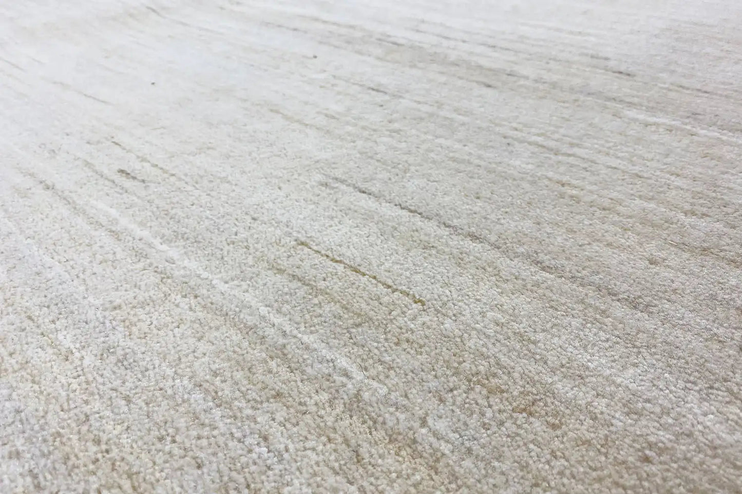Light-colored rug with a fine, even pile and subtle lines
