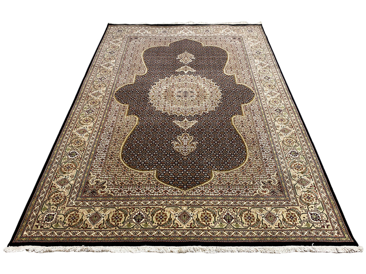 Teppich mit dunkelbraunem Grund, großem Zentralornament, beiger Bordüre und Fransen