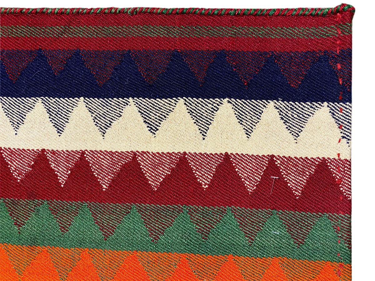 Close-up of a jajim rug: colored stripes with zigzag edges and a woven texture