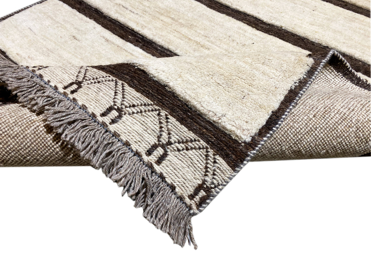Close-up detail: woven ornaments and fringes along the edge of a kilim rug