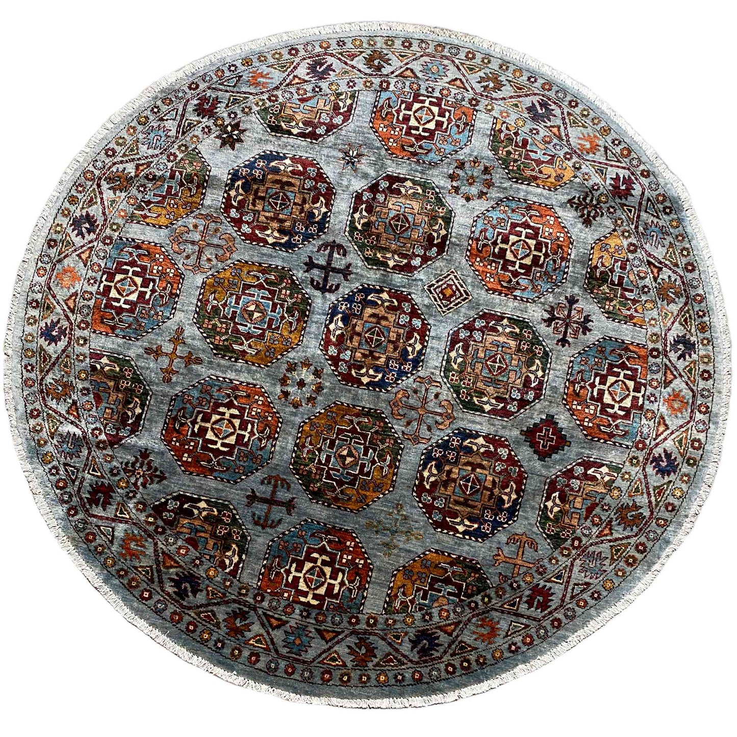 Round rug with a multicolored ornamental pattern on a light gray-blue background