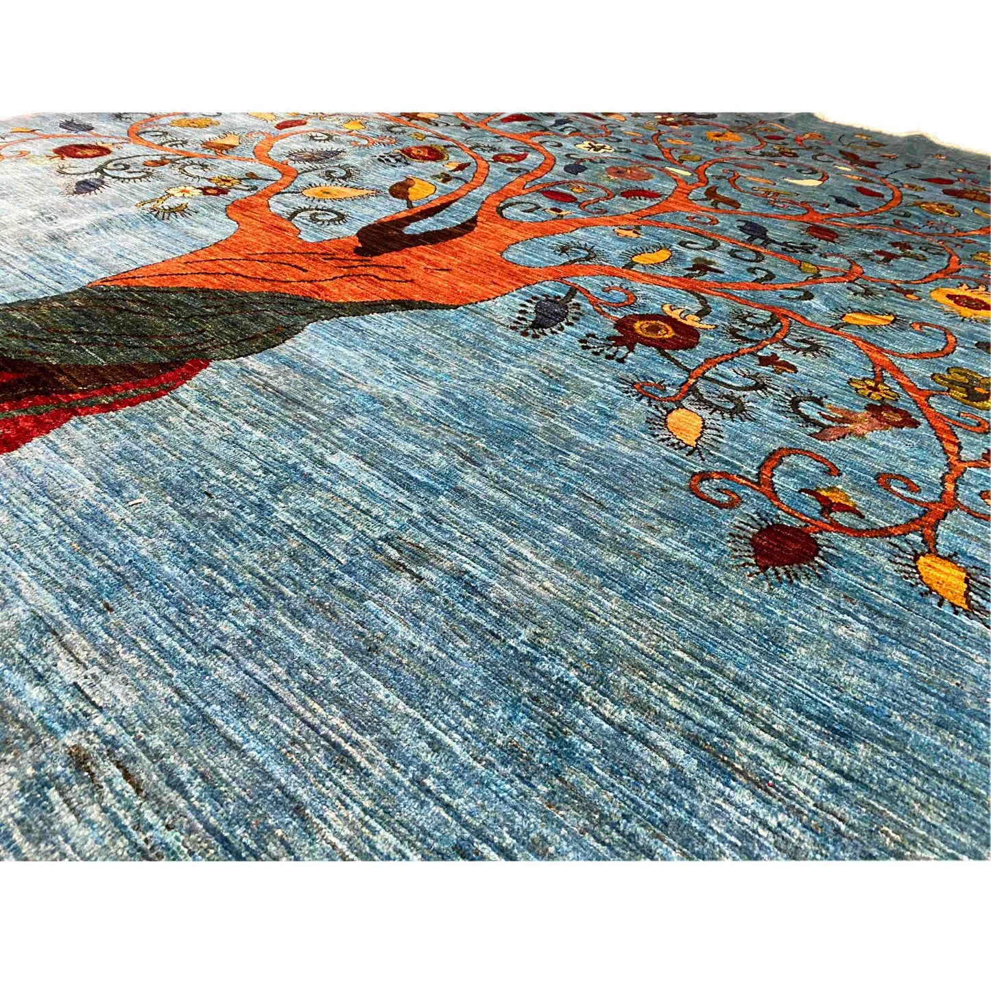 Detail: Blue carpet fabric with a tree motif and colorful ornaments
