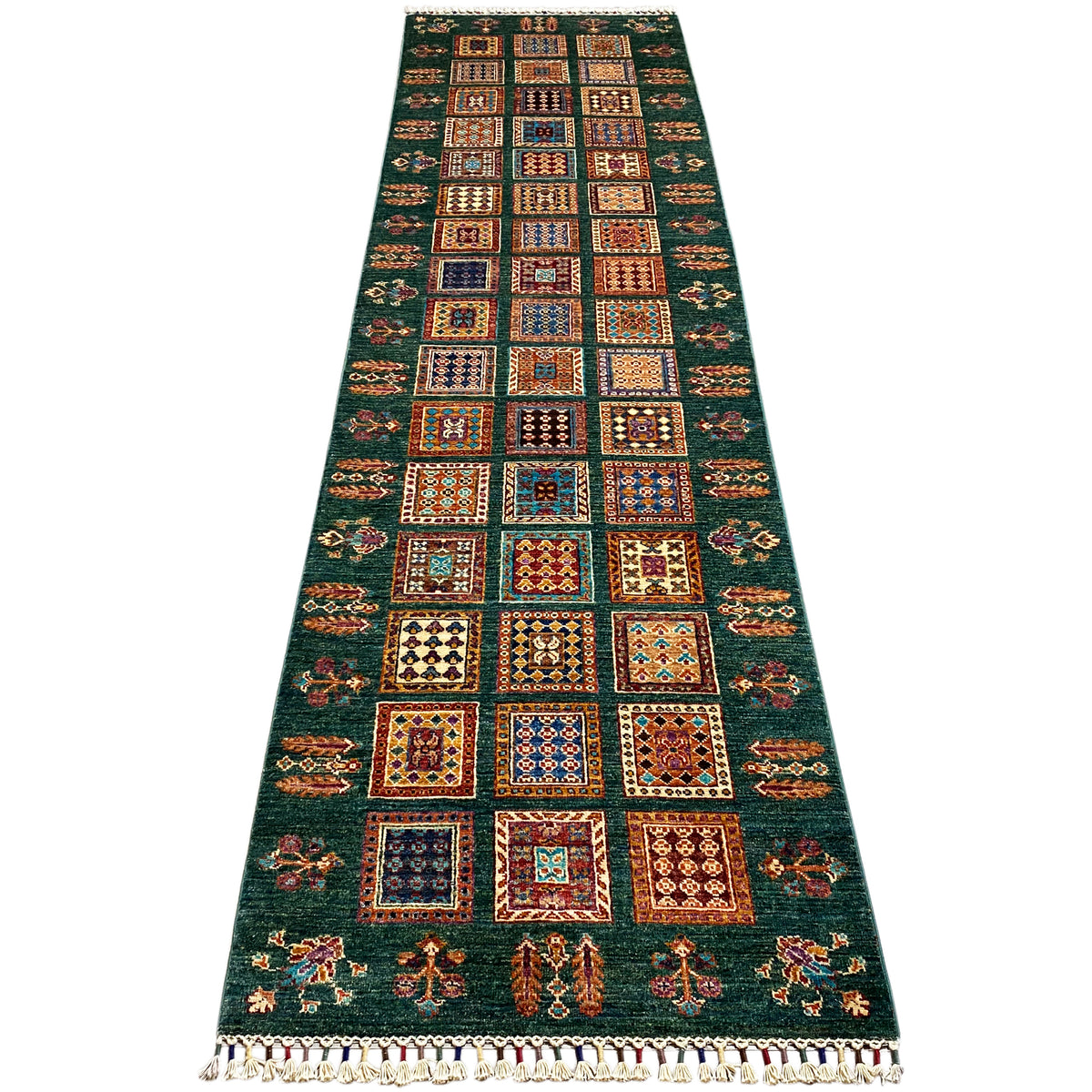 Khorjin runner in a flat view, dark green with patchwork squares and fringed trim