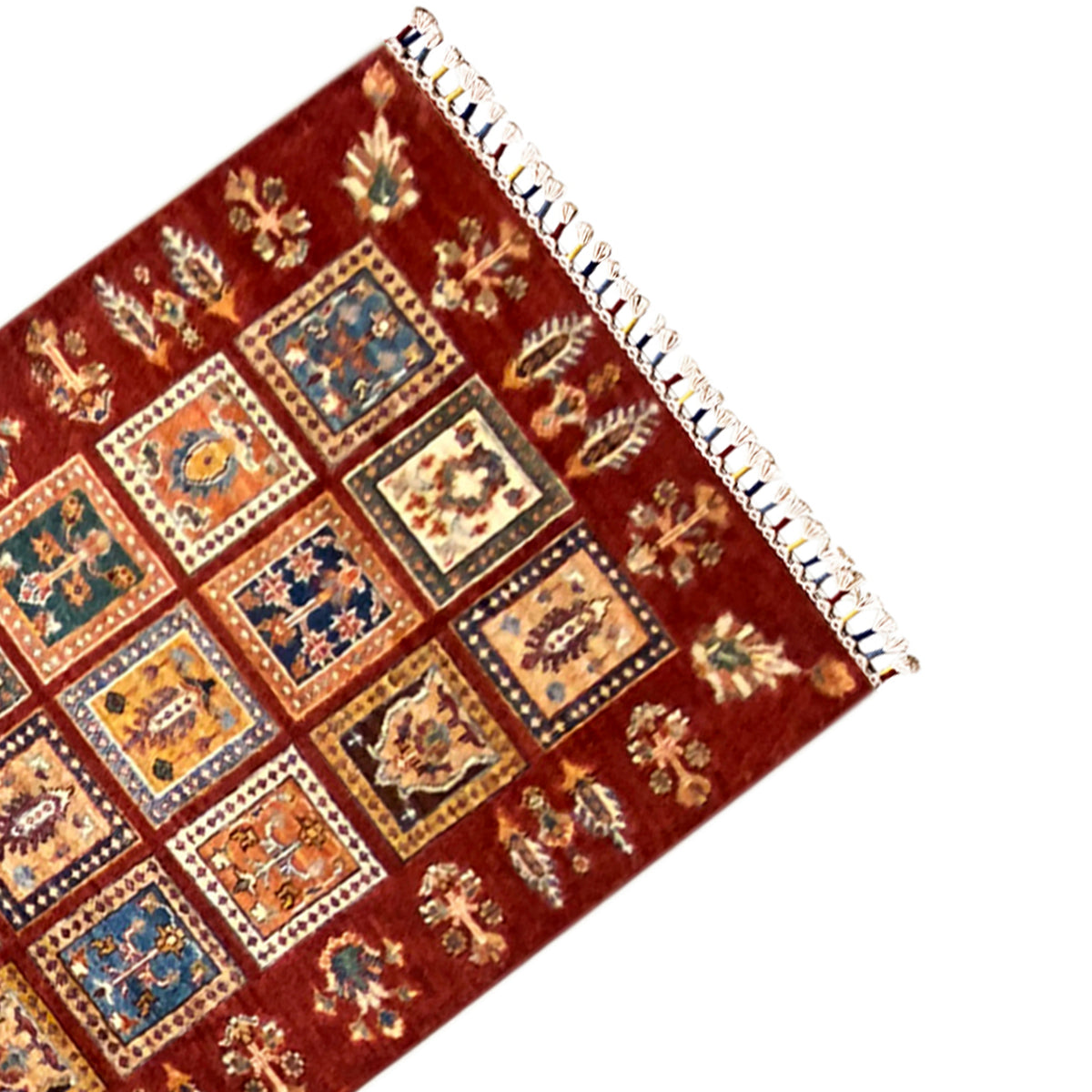 Corner of the Khorjin runner with colorful squares and white shaggy fringes.