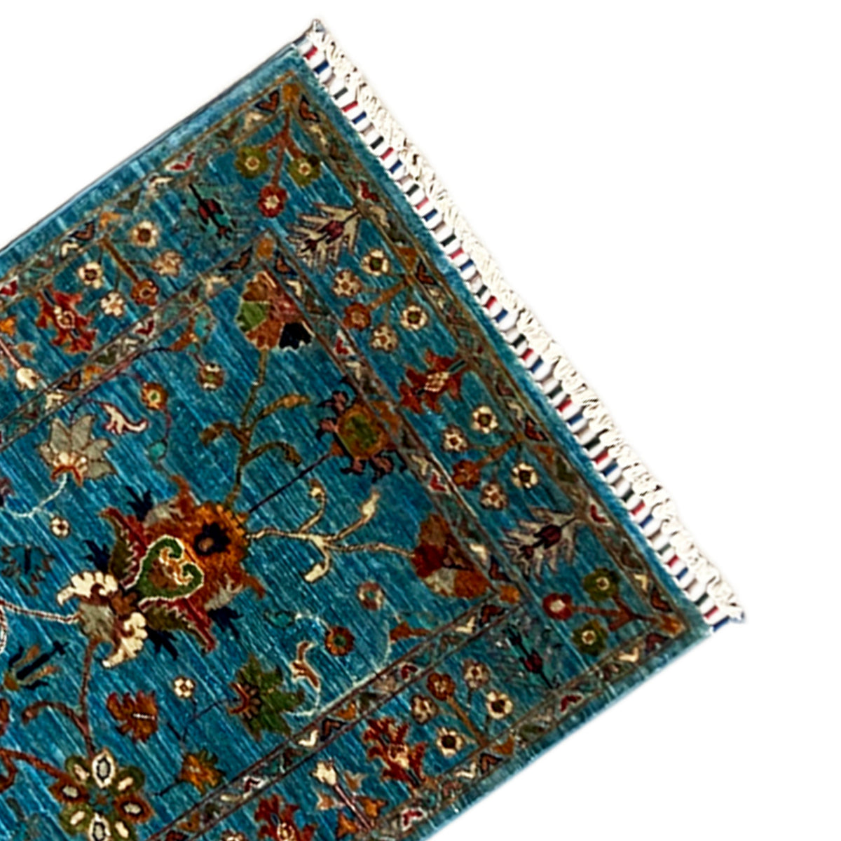 Corner of the hand-knotted runner: blue ornamental pattern with fringes and a bound seam