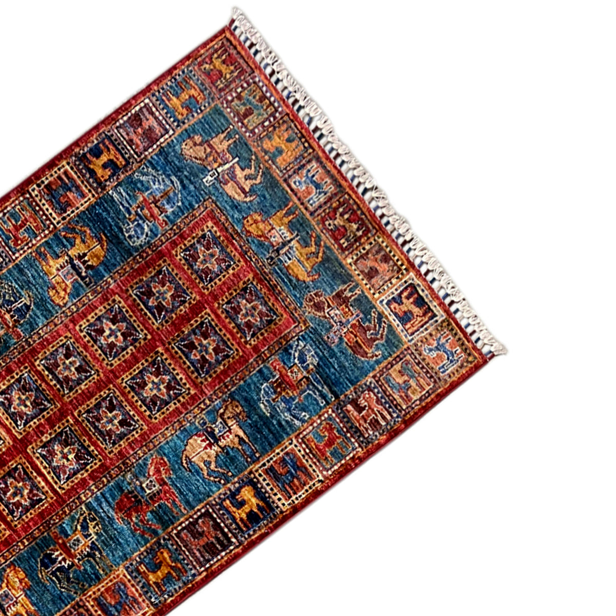 Corner of the hand-knotted Khorjin runner with blue-red ornamentation and tasseled fringe.