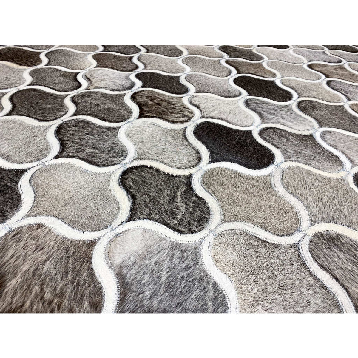 Close-up of a calfskin rug: trefoil-like frames alternating between gray and white
