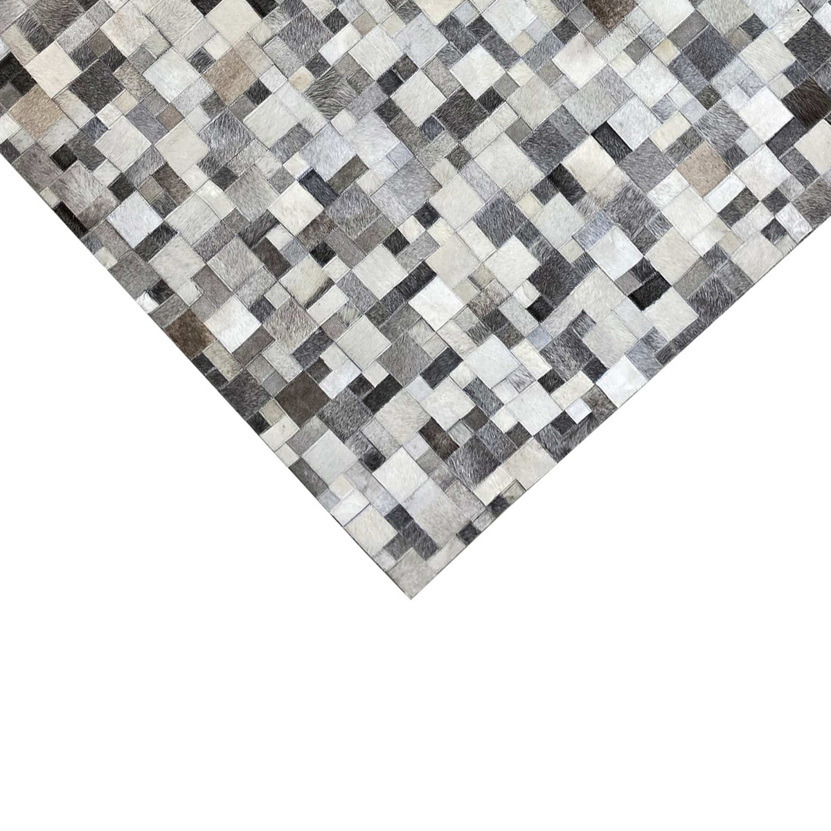 Calfskin rug in detail, geometric patchwork of light and dark leather squares