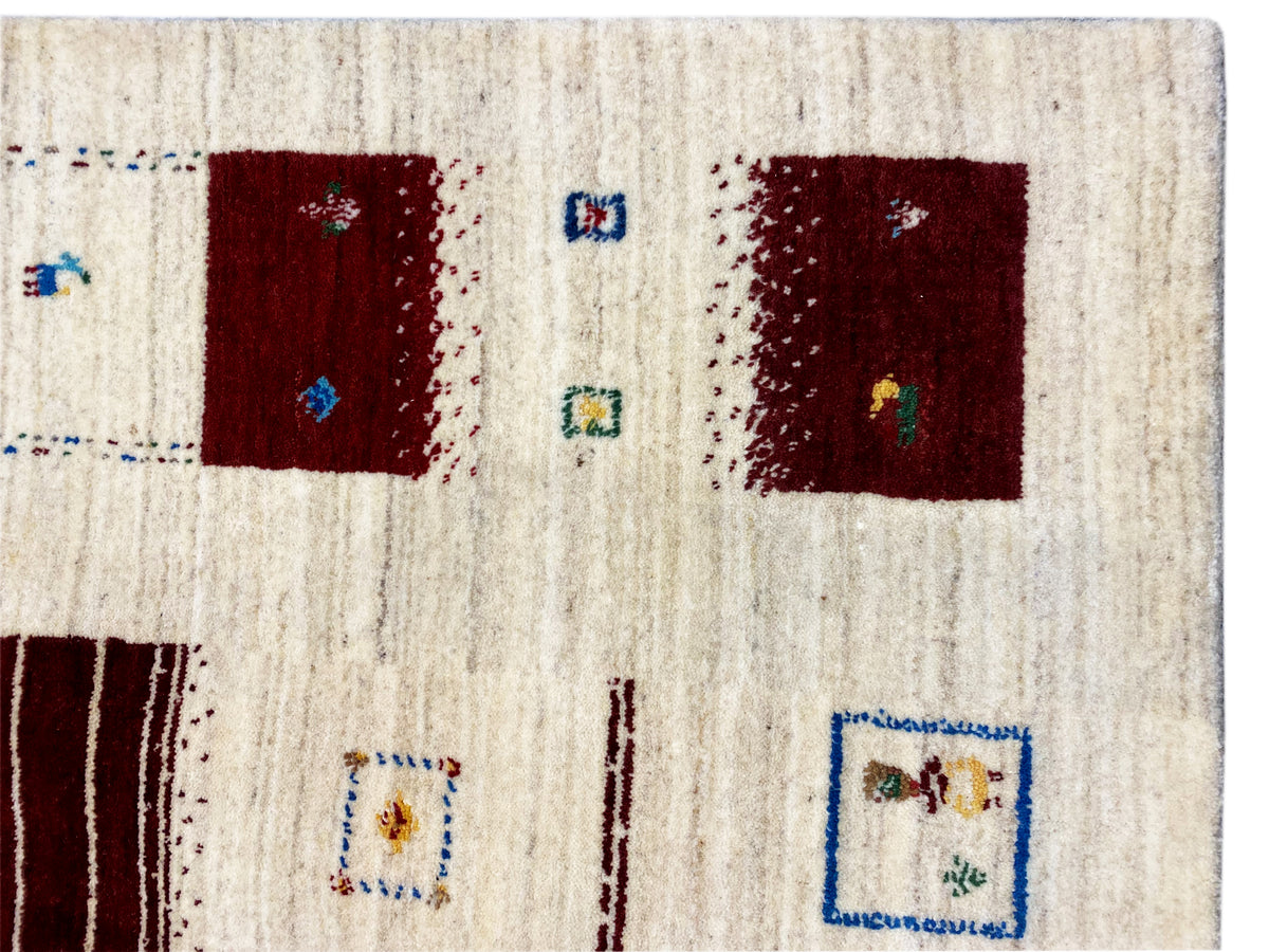 Loom Luri Teppich Nahansicht der Fläche: cremefarben, mit roten Quadraten und Symbolen