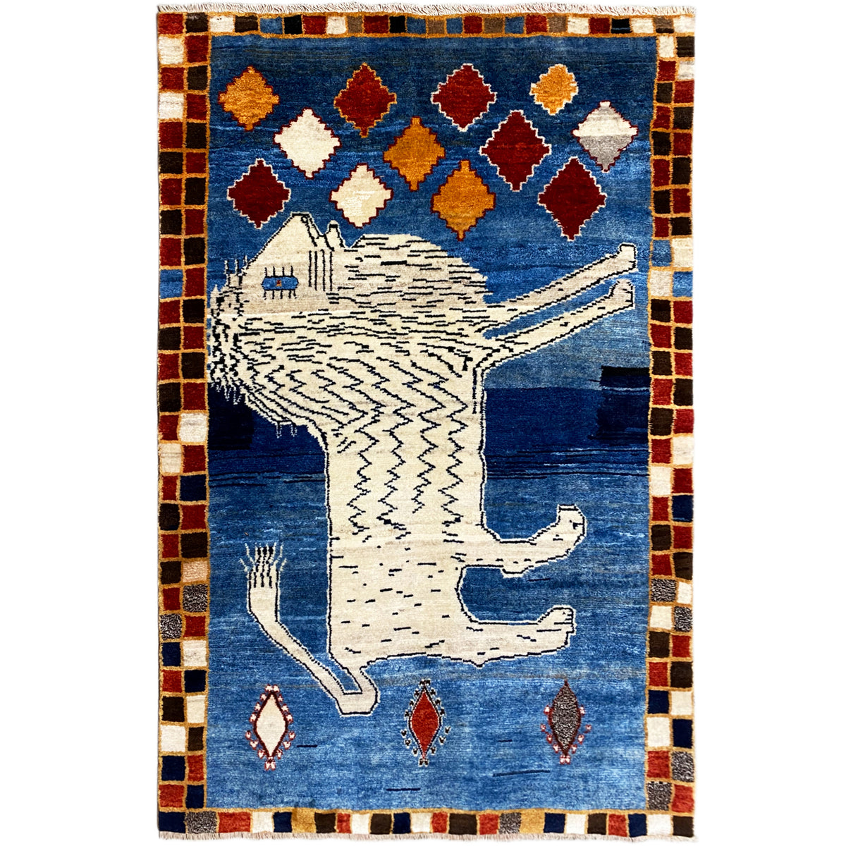 Blue Gabbeh rug with a white lion motif, colorful diamonds, and a checkered border.
