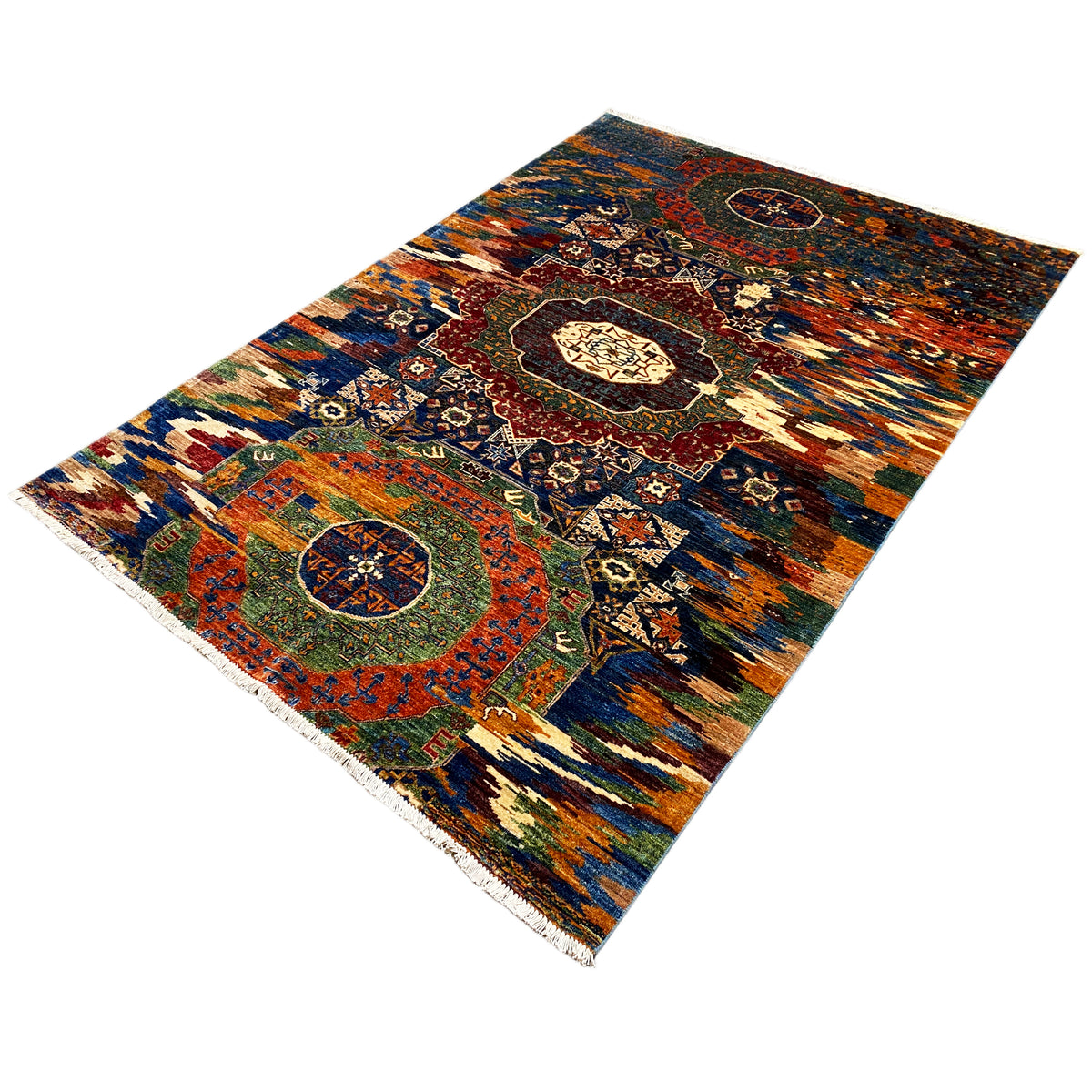 Mamluk rug at an angle, multicolored ornament and medallions, fringes along the edge.
