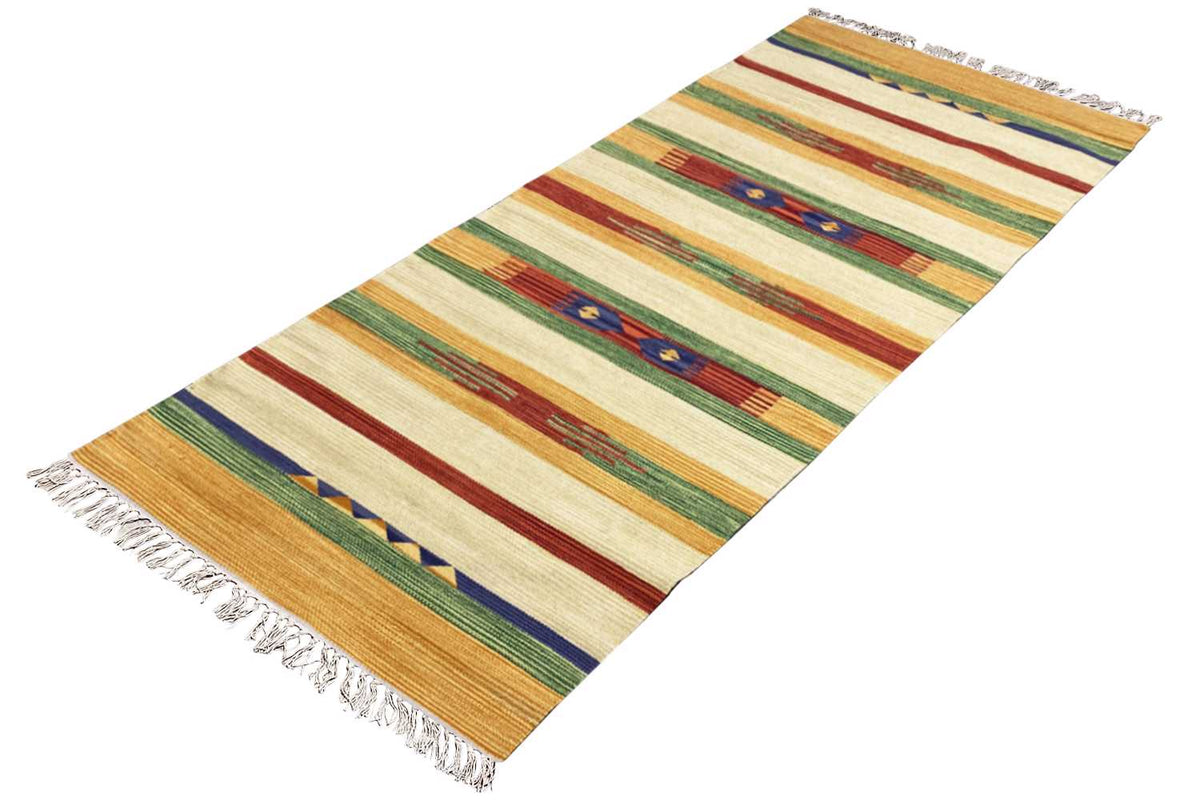 Kilim rug in a diagonal view, striped pattern in cream, yellow, green, red, fringes