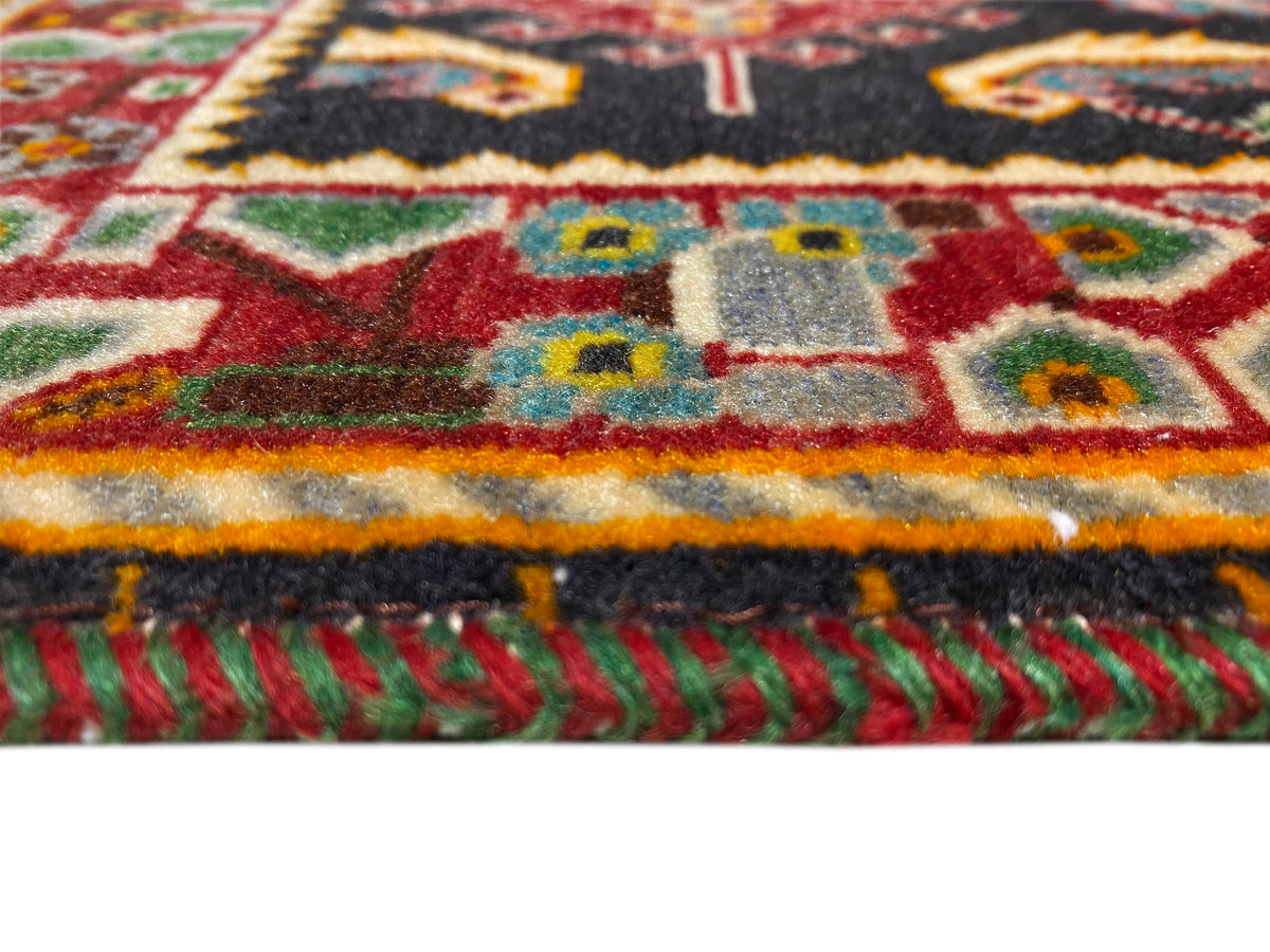 Rug with a colorful border stripe and fringe, red-yellow-green on a black base
