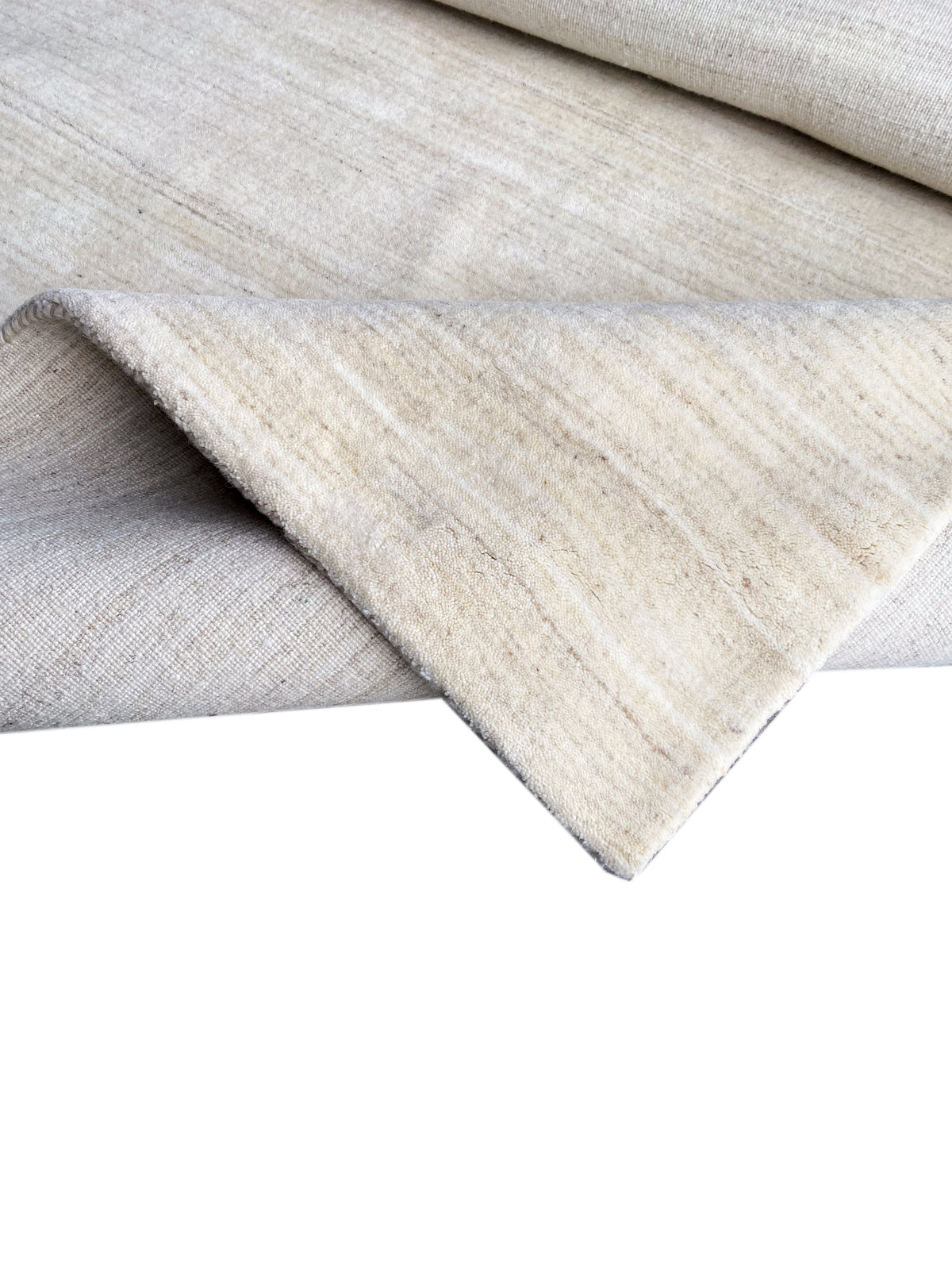 Natural gabbeh rug, folded, fine striped texture and selvedges