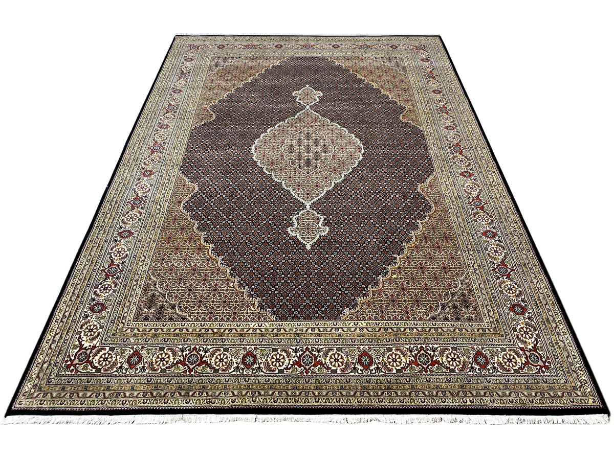 Oriental rug in shades of gray and blue with a dark brown medallion and ornamental border