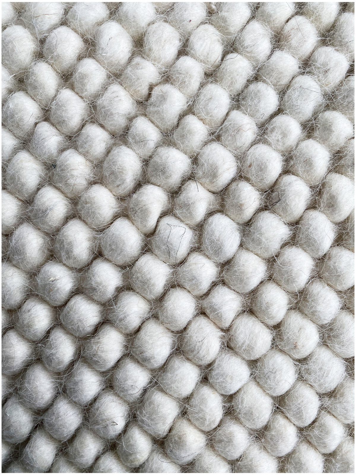 Carpet, close-up: dense wool balls in a grid, light gray/white