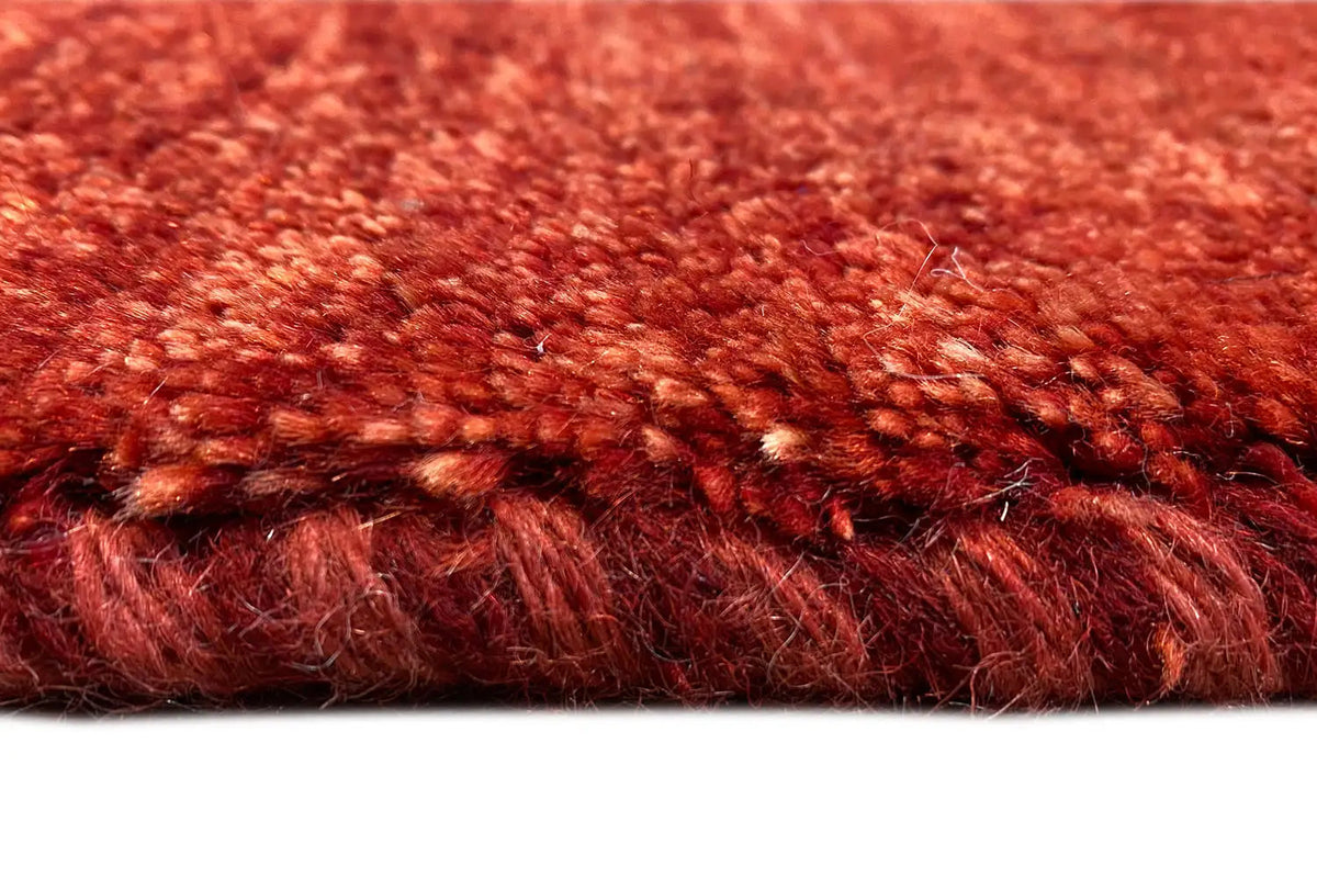Gabbeh rug, detail of the lower edge of the pile with a reddish mottled texture