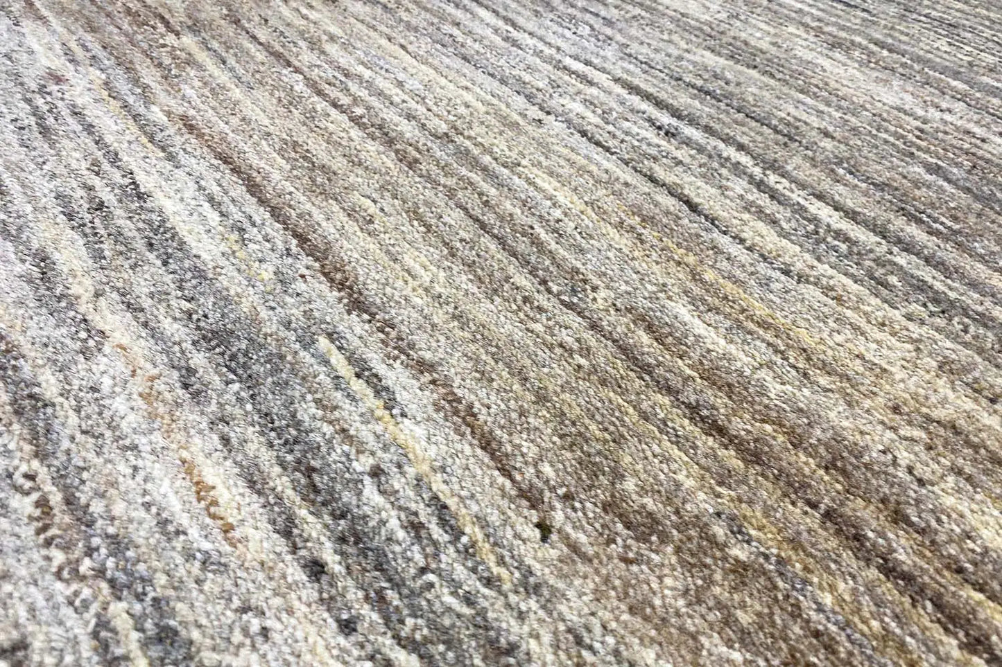 Gabbeh rug surface with fine, elongated lines in light gray and beige