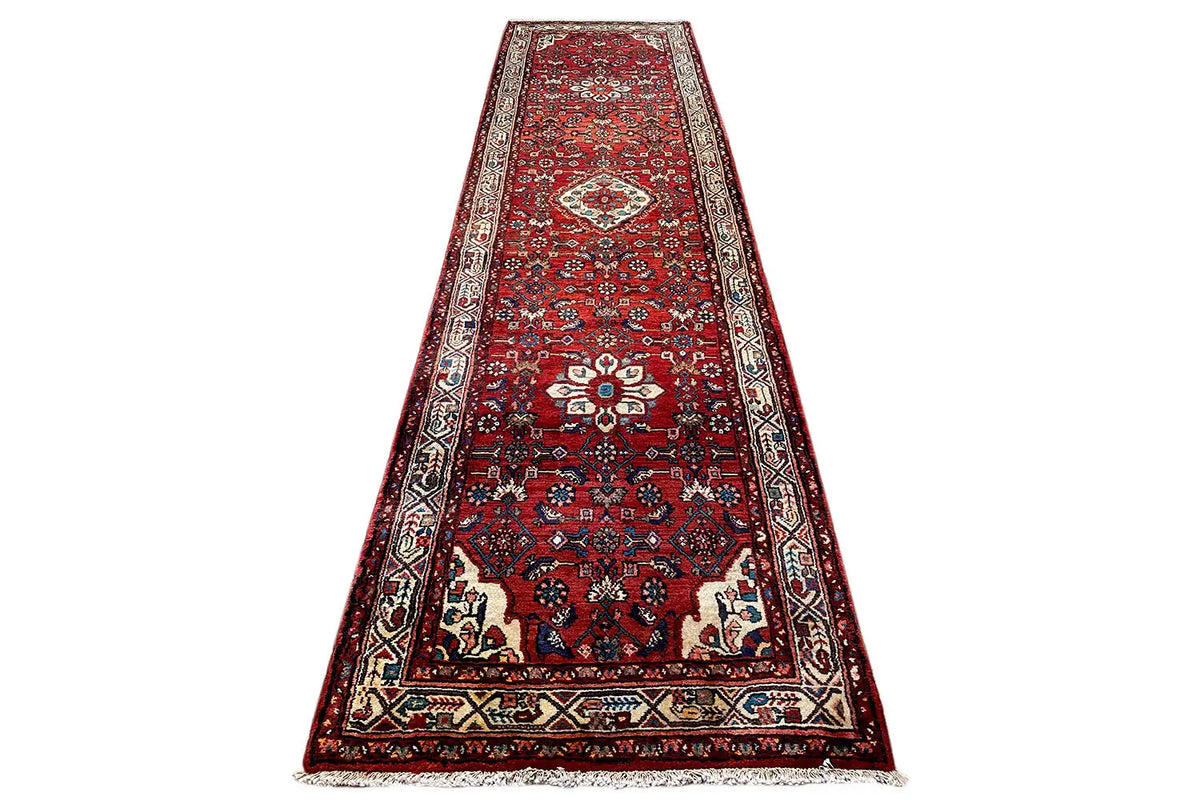 Hamadan rug from above: red ornamental pattern with a border and medallion