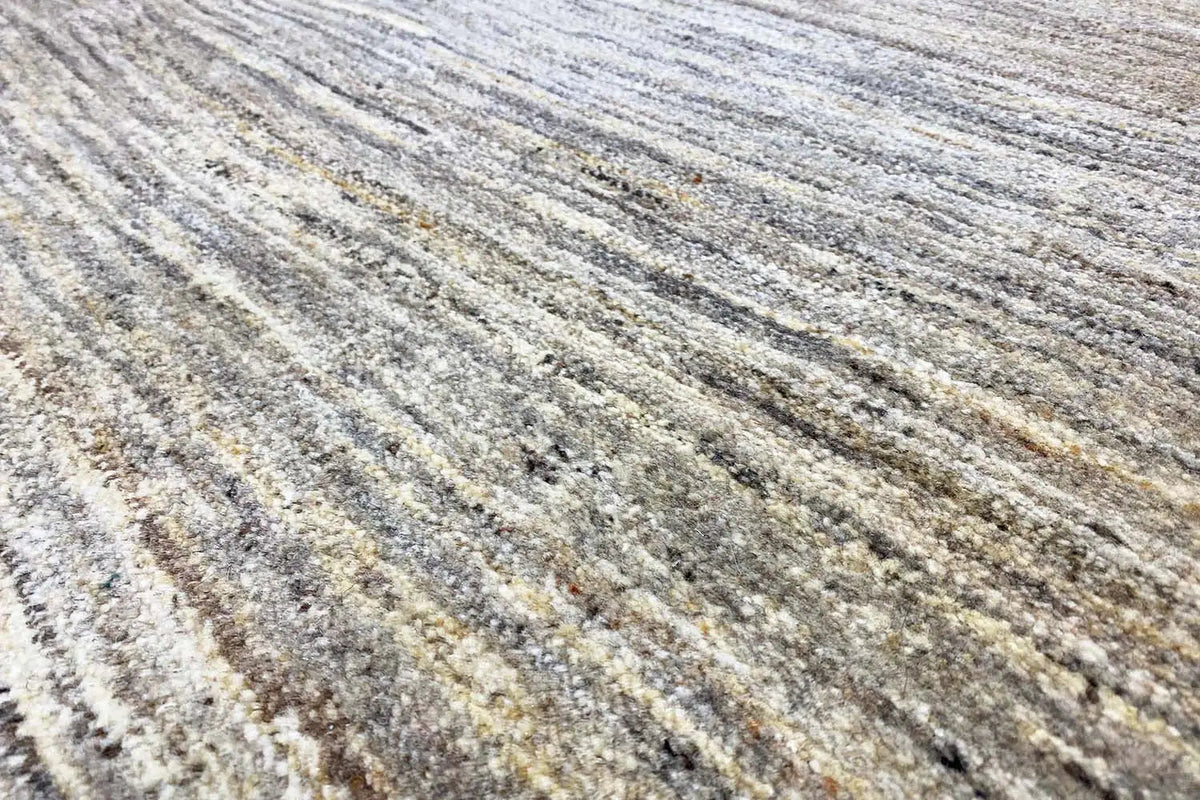 Gabbeh rug with a mottled pattern in light beige, gray, and brown tones