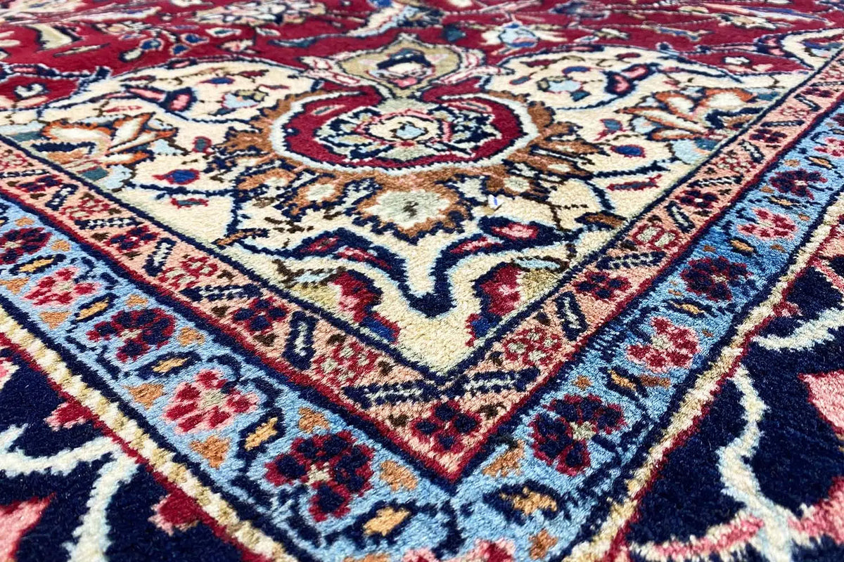 Khorasan carpet: ornamental pattern in red, cream, and dark blue (close-up).