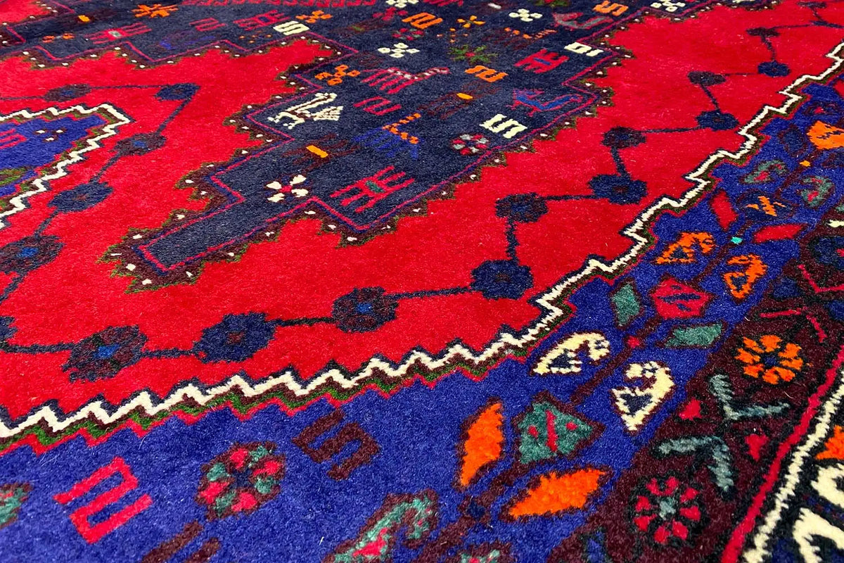 Carpet detail with red areas, blue zigzags, and colorful small accents