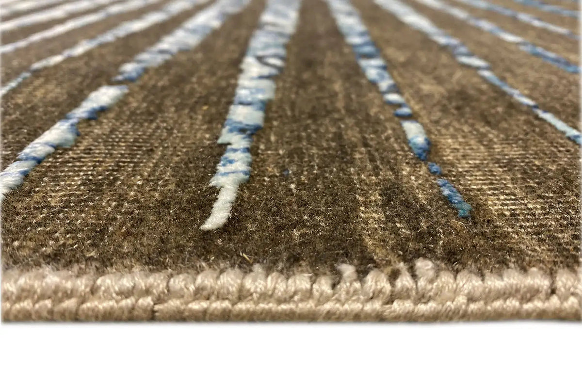 Designer rug with fringes along the edge, brown-blue ornaments, and a bordered trim