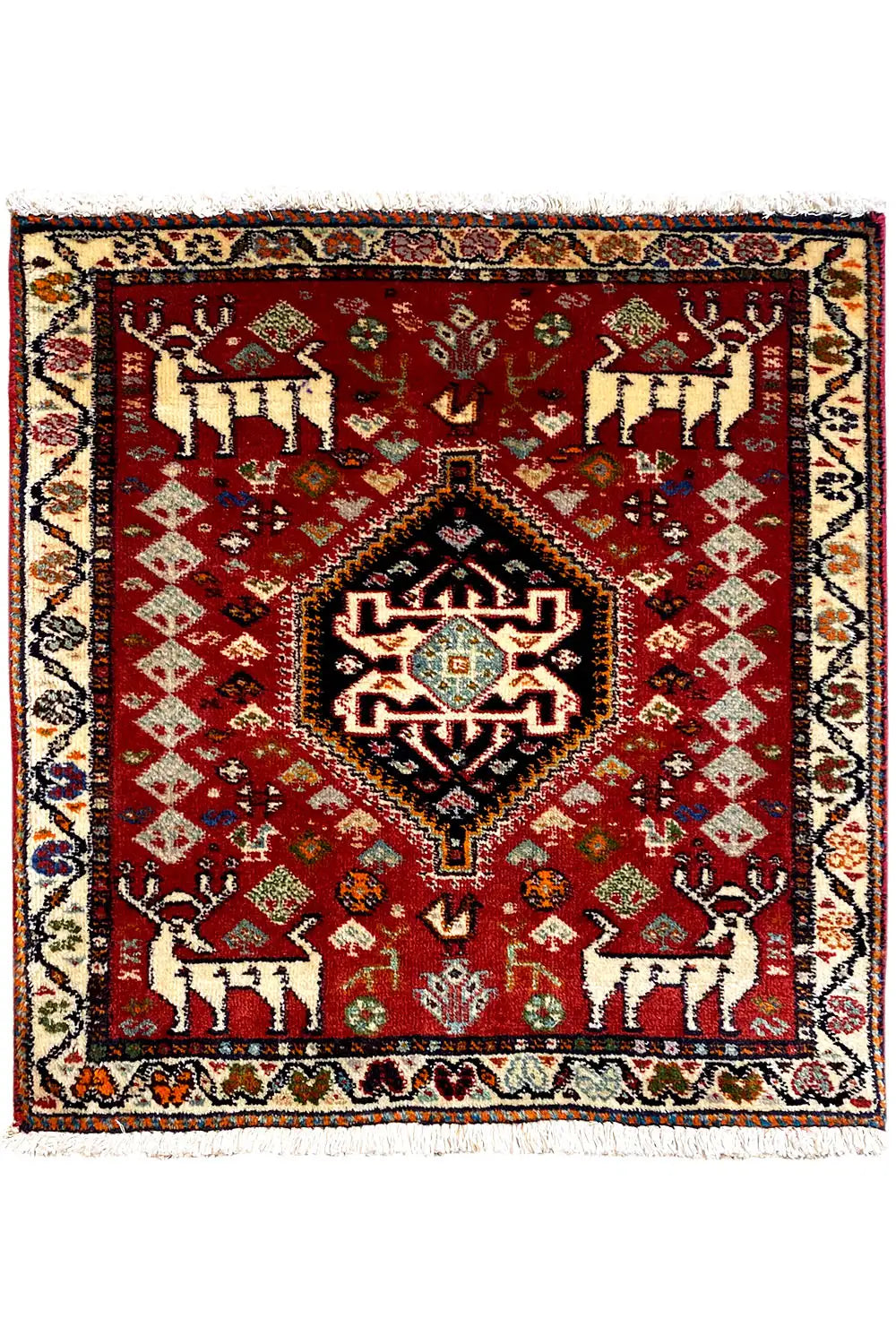 Square red rug with a central medallion, defined border, and fringes