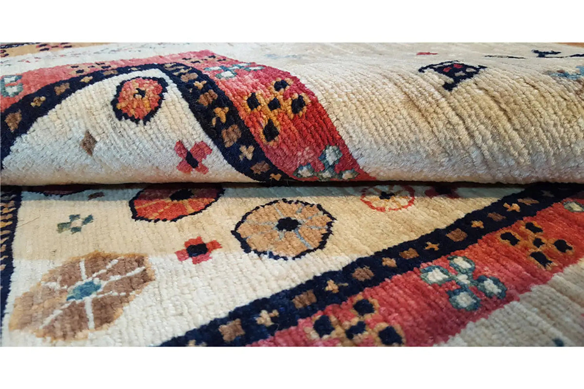 Carpet detail with embroidered figures and geometric motifs in blue, red, and beige