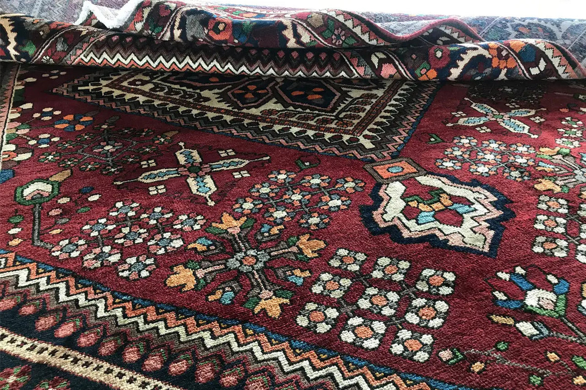 Bakhtiari rug: dark red medallion, zigzag border, multicolored ornaments