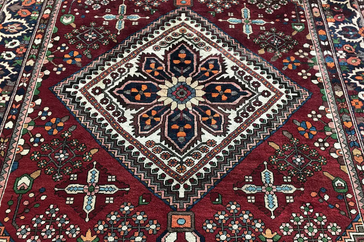 Rug: central diamond pattern with cross ornaments, dark red background