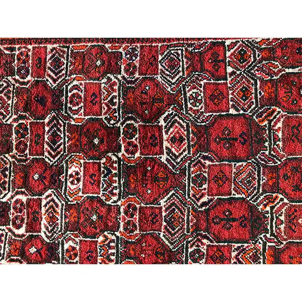 Detailed view: red Oriental rug with black, white, and beige ornaments
