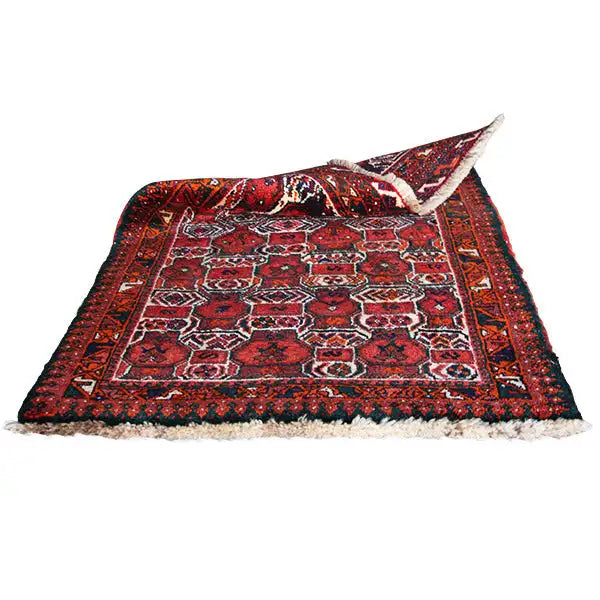 Oriental rug with a red patterned field, zigzag-line border, and fringe