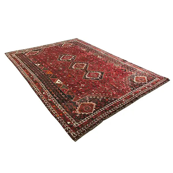 Oriental rug with a red background and patterned medallions, wide decorative border