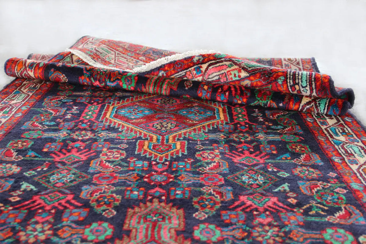 Folded Oriental rug runner with a medallion pattern and colorful border