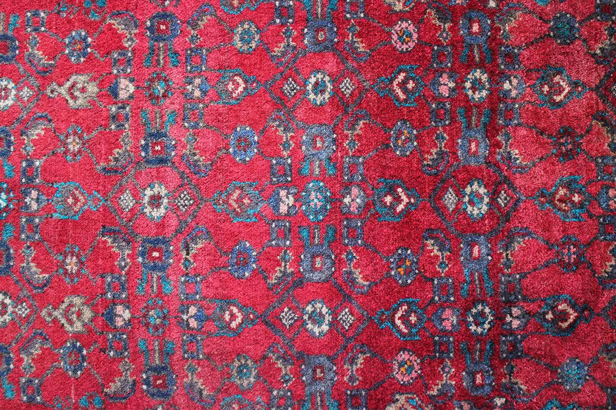 Hamadan runner close-up: red field pattern with blue and beige decorative motifs.