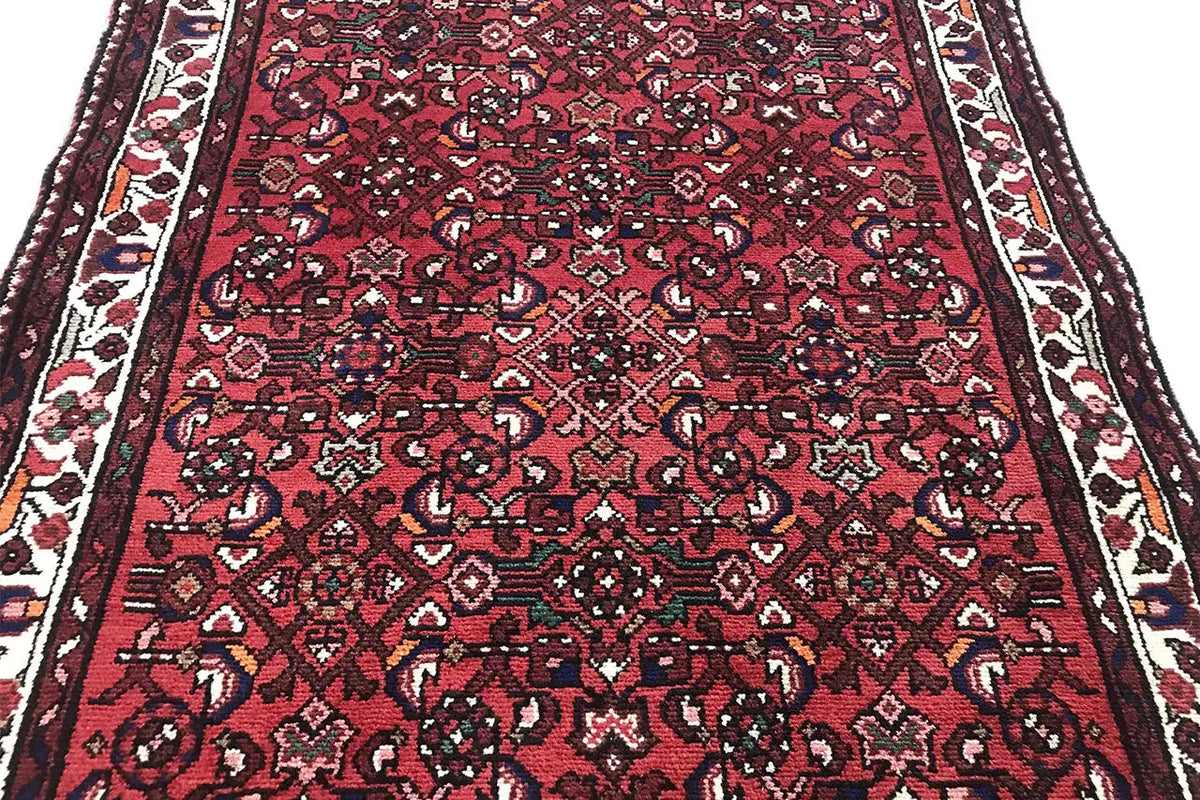 Close-up: Red carpet runner with a small-scale pattern and contrasting border bands