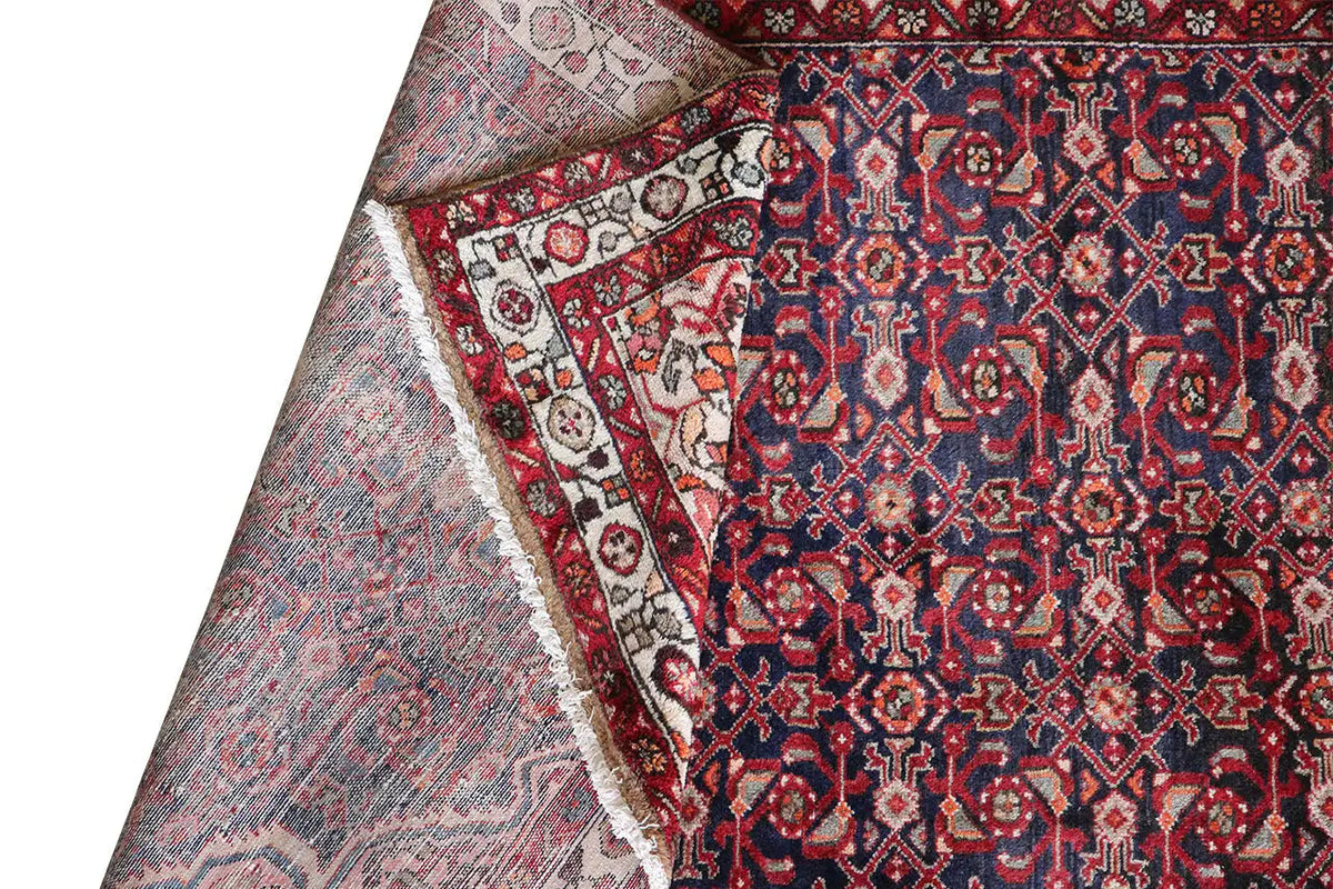 Oriental rug runner, rolled up on the side: blue-red-white ornamental pattern and border