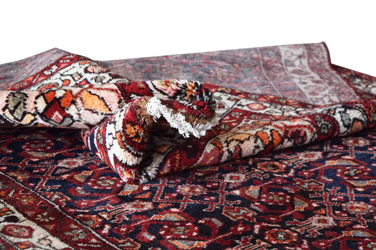 Oriental rug runner with a red field, blue pattern, and folded edge area