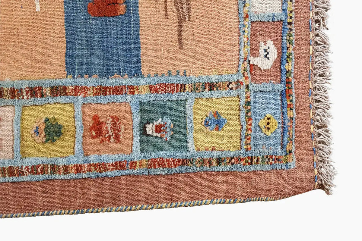 Corner section of a kilim rug with colorful ornaments and a side fringe border