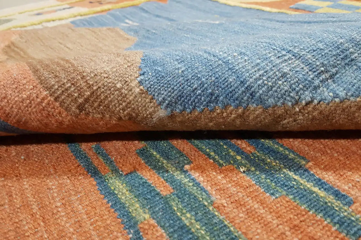 Carpet detail with blue pile and woven patterns in orange and brown
