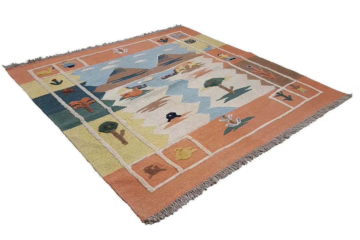 Kilim rug spread out; blue field with animals and trees, orange border, fringes
