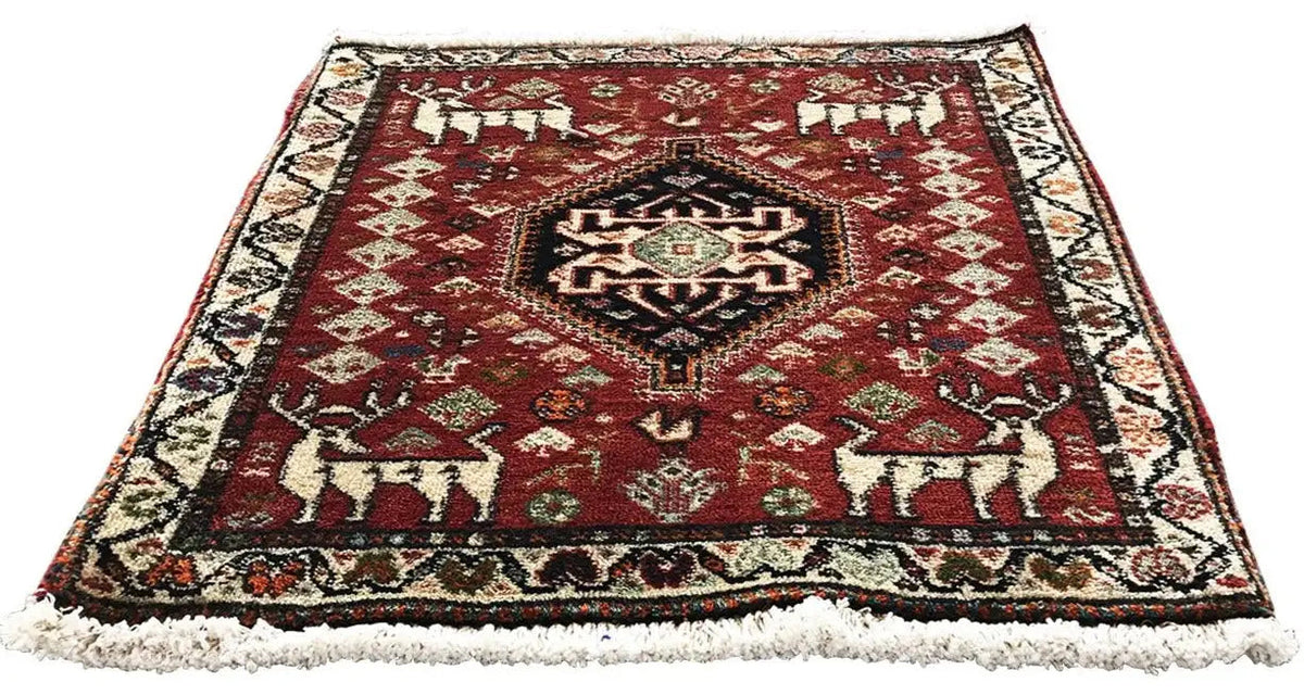 Red rug with a patterned central medallion, multicolored border, and fringe