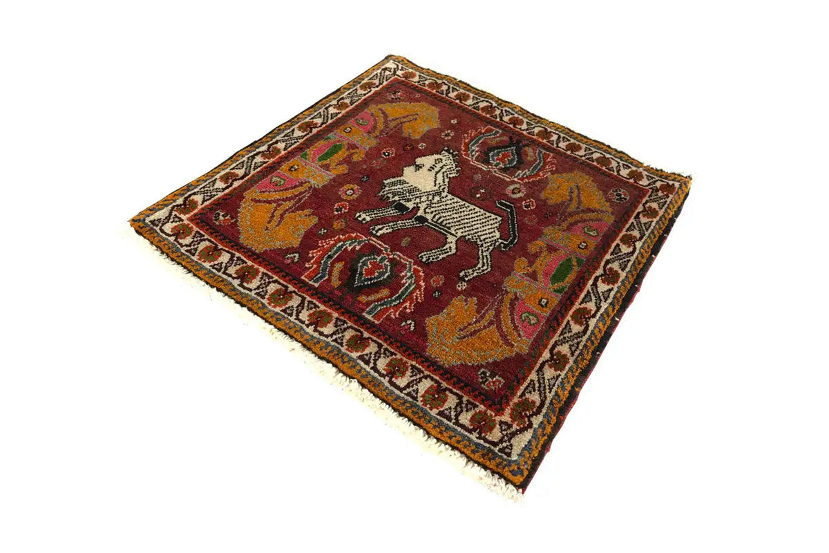 Rug with a red patterned field and white horse in an ornamental border